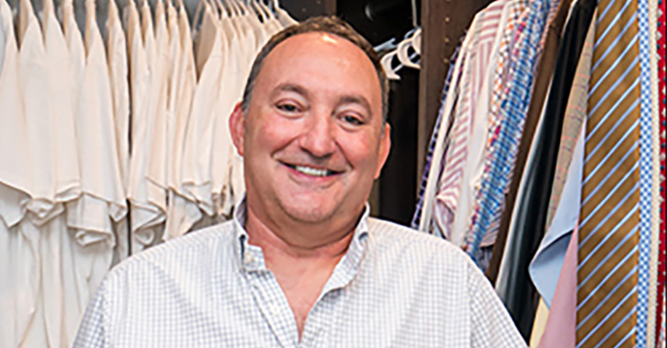 Barry Curewitz standing inside a closet with shirts and ties behind him.